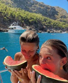 two girls eating watermelon on a boat