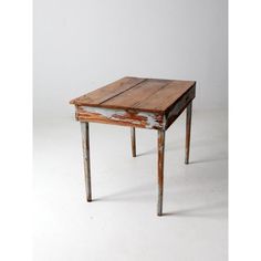 an old wooden table sitting on top of a white floor