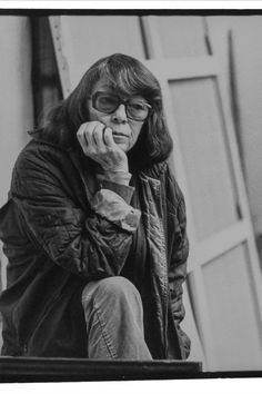 a black and white photo of a woman talking on a cell phone while sitting down