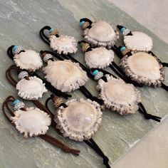 six hair clips with seashells on them sitting on top of a marble slab