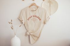 Stay Golden tshirt, You're so Golden shirt, Retro Boho Shirt, Women's Crewneck Tee, 70's Shirt, Sun tee, Women's Tee, positive message shirt ► SHIRT DETAILS We use Bella + Canvas t-shirts. UNISEX sizing - they are meant to have a loose fit. Please refer to our sizing chart in the photos for measurements along with tips on the fit for both ladies and guys. *If you are looking for a different fit, tank top, sweatshirt or kids shirt, please contact us and we can accommodate your request. ► CARE INSTRUCTIONS:  Wash shirts with cold water, inside out, and hang to dry. NEVER put an iron directly on the image. ► PROCESSING TIME: 2-5 Business Days. Please TRIPLE check your address. We are not responsible for items going to the wrong address. If you entered the wrong address, please contact us righ Peds Nurse, Nurse Sweater, Cute Teacher Gifts, Space Cowgirl, Kindergarten Teacher Shirts, Western Tee, 70s Shirts, New Nurse, Nurse Graduation