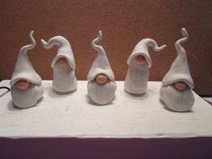 three small figurines with white hair and beards on top of a table