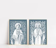 two framed art prints depicting the virgin and saint mary in blue on a white wall