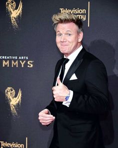 a man in a tuxedo gives the thumbs up sign on the red carpet