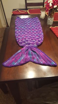 a knitted mermaid tail sitting on top of a wooden table