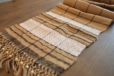 a brown and white blanket laying on top of a wooden floor