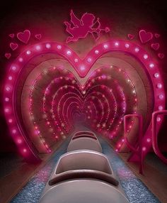 there is a row of chairs in front of a heart shaped wall with lights on it