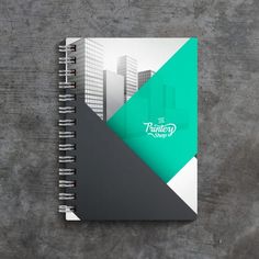 an open spiral notebook with the company's logo on it, sitting on a concrete surface