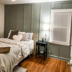 a bed sitting in a bedroom next to a window with blinds on the windowsill