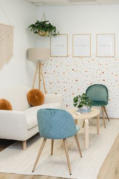 a living room filled with furniture and plants on the wall next to a white rug