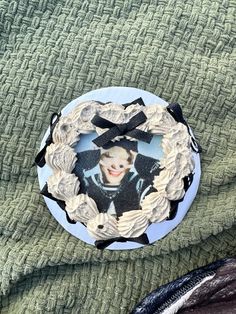 a cake that is on top of a green blanket with an image of a boy