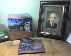 a desk with a cell phone on it and a calendar in front of the box