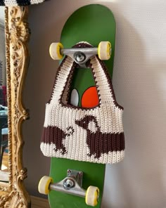 a green skateboard with a knitted bag hanging on it's side next to a mirror