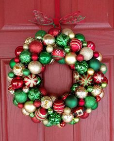 a christmas wreath hanging on a red door with ornaments all over the front and side