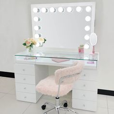 a desk with a chair, mirror and lights on it