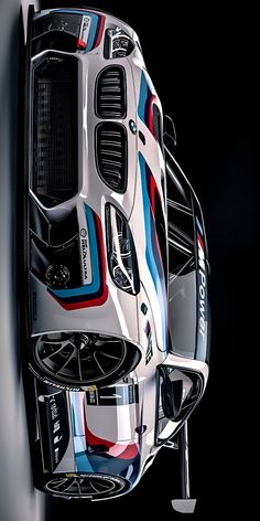 the front end of a white car with colorful stripes on it's body and hood