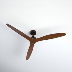 a wooden ceiling fan mounted on the side of a wall