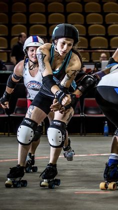 three women rollerblading in an indoor arena