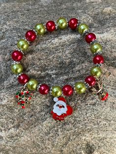 This bracelet is made with red Pearl beads, Tibetan bead caps, green Pearl beads and have an enamel santa charm, reindeer charm and a candy Charm. Note: Colors may vary depending on your monitor Shipping Info: All orders are shipped from Canada and they are sent through Canada Post.  If you would like expedited/faster shipping, it will cost more and you can reach out to me directly and I will give you pricing. Within Canada: Sent regular mail with no tracking and it can take 5-10 business days t Holiday Green Beaded Bracelets, Christmas Green Beaded Bracelets, Green Beaded Bracelets For Holiday, Christmas Holiday Green Jewelry, Green Christmas Holiday Jewelry, Multicolor Beaded Bracelets For Christmas Holiday, Green Beaded Bracelets For Christmas, Red Christmas Festive Bracelets, Multicolor Beaded Bracelets For Christmas