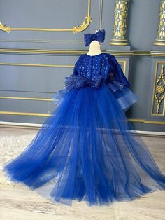 Dress your little princess in enchanting style with our Royal Blue Beaded Shiny Long Train Toddler Girl Dress. This exquisite blue girls dress features long sleeves, a stunning long tail with feather detail, and a magnificent big bow that adds a touch of royalty to any special occasion. Key Features: Royal blue design for a regal and sophisticated look. Intricate beading that adds a touch of glamour and sparkle. Long sleeves for a graceful and elegant appearance. Shiny long train with feather detail for a whimsical touch. Big bow princess dress that enhances the overall charm. Perfect as a fluffy flower girl dress or for any special event. This toddler girl dress is meticulously crafted to make your little one stand out in the crowd. Whether it's a wedding, party, or photoshoot, this dress Royal Blue Princess Dress For Party, Royal Blue Dress For Pageants, Blue Tulle Tutu Dress For Fancy Dress, Royal Tulle Party Dresses, Royal Tulle Dresses For Party, Blue Sequin Dress For Fancy Dress, Blue Sequin Dress For Fancy Occasions, Blue Embellished Princess Dress For Wedding, Blue Sequin Dress For Dress-up