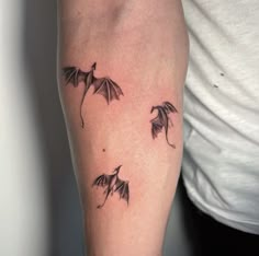 a woman's arm with three small bats on the left side of her arm