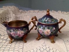 two matching tea cups and saucers on a doily