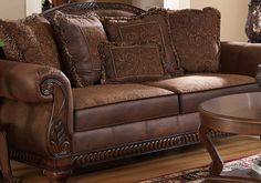 a living room filled with lots of brown furniture