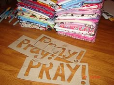 a pile of cloths sitting on top of a wooden floor next to scissors and paper