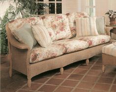 a living room filled with furniture next to a large window and potted plant on top of a hard wood floor