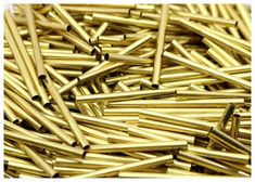 many gold colored nails are scattered together on the floor, and there is no image here to provide a caption for