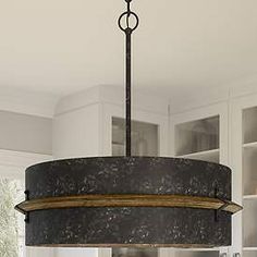 a black and white chandelier hanging from a ceiling in a kitchen with marble counter tops