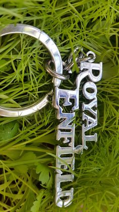 there is a keychain that has the word love in it on top of some grass