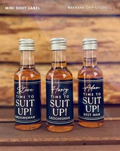 three bottles of syrup sitting next to each other on a wooden table with the label saying time to suit up