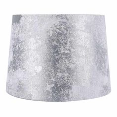 a lamp shade that is silver and white with some black spots on the bottom of it