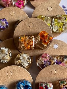 there are many different types of earrings on the table together, including one with flowers