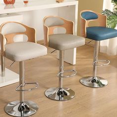 three modern bar stools in front of a counter