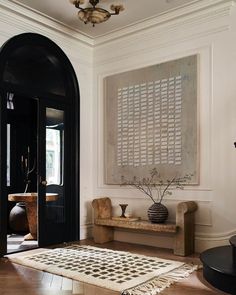 a black and white area rug in front of a doorway with a painting on the wall