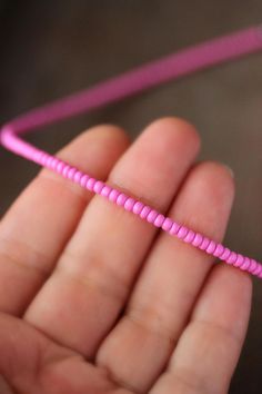 a person holding a pink string in their hand