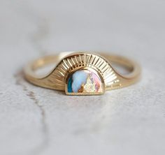 Cyra Oyster turquoise Ring A ring that will accompany you through your day from the sunrise till the sunset. A perfect bohemian style ring. Price is for main ring only. DETAILS
 Main Ring   Style: Solitaire  Gemstone: Oyster turquoise  Color: Multicolor  Shape: Half Moon  Cut: Cabochon  Measurements: 7x5 mm  Band   Material: 14k Gold: yellow, white, rose 18k Gold: yellow, white, rose  Other Metal: platinum  Sizing: We are using US metric system  Customization Options This design can be made with gemstones of your choosing. If you would prefer a custom ring, please contact us before purchase. Procedure Information Please select the material, ring size, and finish from the drop-down menu on the right side of the listing. Procedure Information Free Insured Shipping: The item will be gift wrap Unconventional Wedding Rings, Engagement Rings White Gold, Unconventional Engagement Rings, Ring With Gemstone, Bohemian Style Rings, Sunstone Ring, Sun Ring, Ring Wrap, Moon Cut