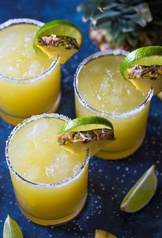 three margaritas with lime slices on the rim