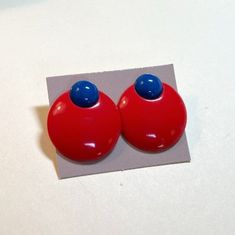 A bright and graphic pair of button earrings from Avon, Colorworks pierced earrings with surgical steel posts, red and blue, 1987.  New old stock, in the original Avon box. Each earring at about 1 1/4 inches long by about 1 1/8 inches wide.  Plastic red and blue graphic circles.  Silvertone metal surgical steel posts.  Butterfly backs, one is stamped Avon.  New, old stock, in the original little Avon box.  These appear to never have been worn.   Noticeable wear to the box.  Please note that these were stored with Avon perfume, and some of the boxes have a lingering Avon scent! You can find more vintage pins here: https://www.etsy.com/shop/OtterCatHaus?section_id=17082336&ref=shopsection_leftnav_2 Please convo with any questions. I combine shipping and refund overages of more than fifty cen Retro Blue Earrings For Pierced Ears, Retro Red Round Earrings, Red Retro Round Earrings, Fifty Cent, 80s Earrings, Avon Perfume, Blue Graphic, Button Earrings, Earrings Red