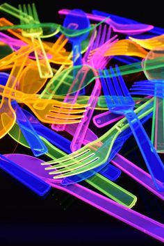 colorful plastic forks and spoons on a black background