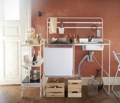 a kitchen with red walls and white appliances on the counter, along with other items