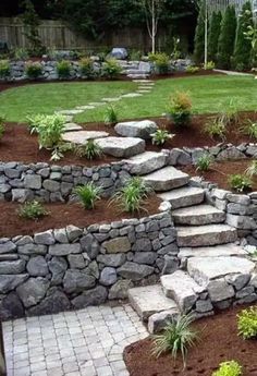 a garden with stone steps leading up to the grass