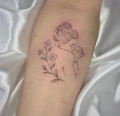 a woman's arm with a tattoo on it that has flowers growing out of it