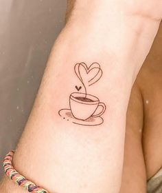 a tattoo on the arm of a man with a coffee cup and heart in it