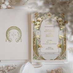 a wedding card with flowers on it next to a bouquet of white and yellow flowers