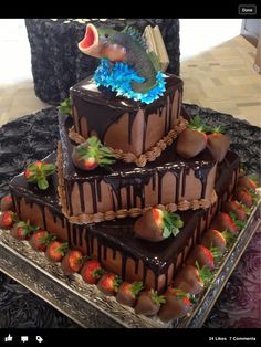 a triple layer chocolate cake with strawberries on the bottom and strawberry decorations on top