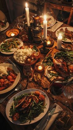 a dinner table is set with food and candles