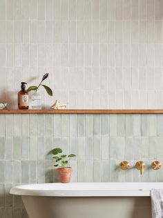 a white bath tub sitting next to a wooden shelf